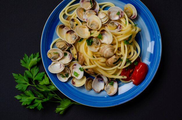 Concept De Fruits De Mer Italien Traditionnel Spaghetti Aux Palourdes Ou Plateau Tomate Et Herbes Photo Premium