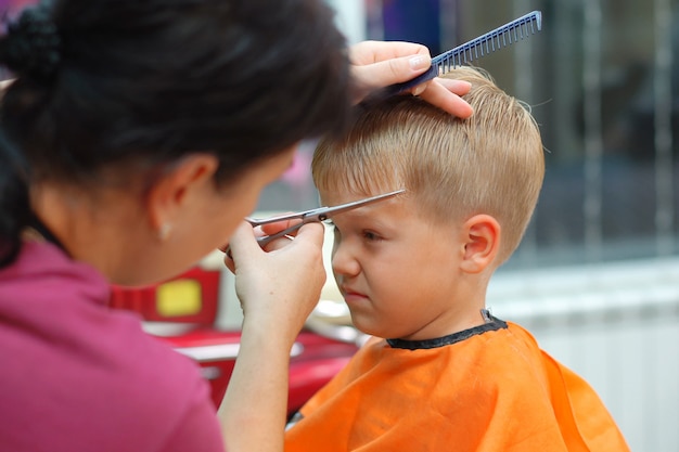 Coupe De Cheveux D Un Petit Garcon Dans Un Salon De Coiffure Pour Enfants Photo Premium