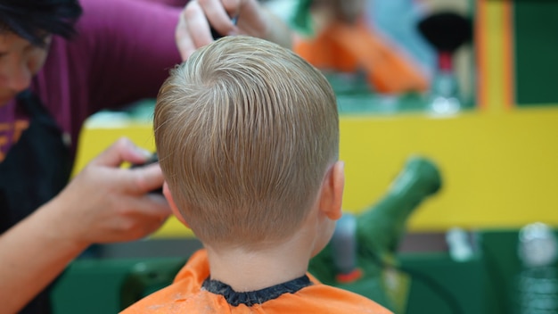 Coupe De Cheveux D Un Petit Garcon Dans Un Salon De Coiffure Pour Enfants Photo Premium