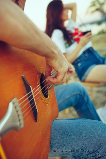 Couple Assis Et Reposant Sur La Plage à Jouer De La Guitare Un Jour Dété Près De La Rivière 