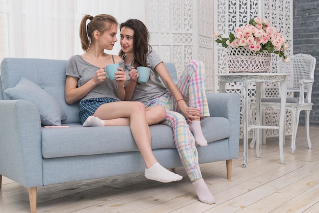 Couple Lesbien Tenue Tasse Café Séance Sur Sofa