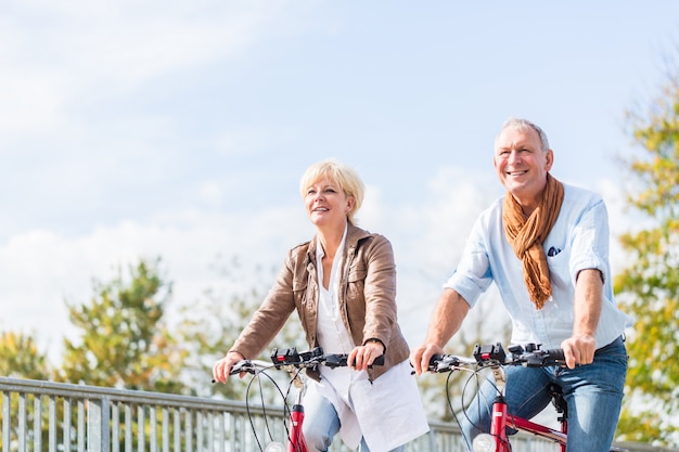 Couple de personnes âgées avec des vélos sur le pont Photo Premium
