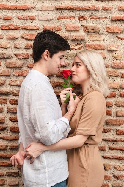 Couple Romantique Embrasse Tout En Maintenant Rose Photo Gratuite