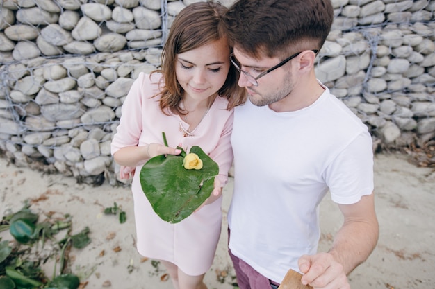 Couple Tenant Une Grande Feuille Avec Une Fleur Jaune