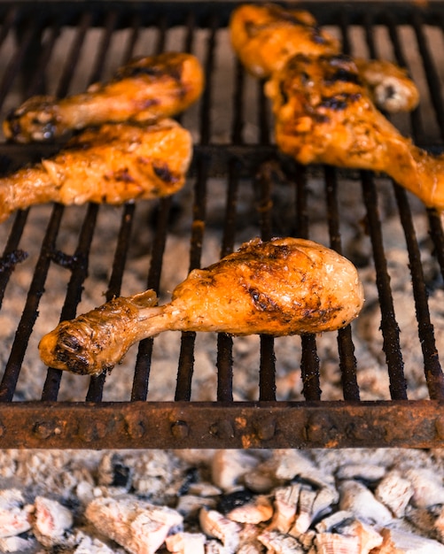 Cuisses de poulet brillantes grillées sur le gril chaud Photo gratuit