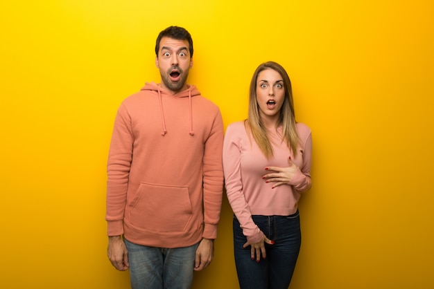Dans la saint valentin groupe de deux personnes sur fond jaune avec expression faciale surprise et choquée Photo Premium