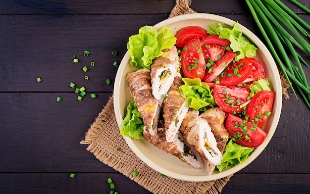 Délicieux rouleaux de poulet farcis au fromage et aux épinards enveloppés dans des lardons de lard, vue de dessus Photo Premium