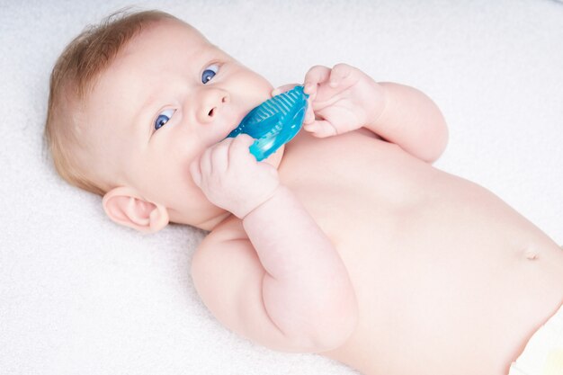 Les Dents Du Bebe Sont Coupees Enfant Mignon Aux Yeux Bleus Grignote Un Jouet Photo Premium