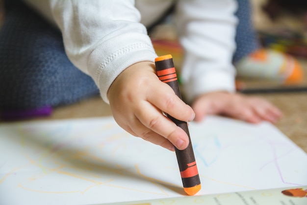 Dessin De Bebe Avec Un Crayon Orange Sur Le Papier Photo Gratuite