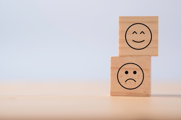 Deux Emotions De Joyeux Et De Triste Qui Impriment Des Serigraphies Sur Des Cubes En Bois Enquete Sur L Experience Client Et Concept De Retroaction De Satisfaction Photo Premium