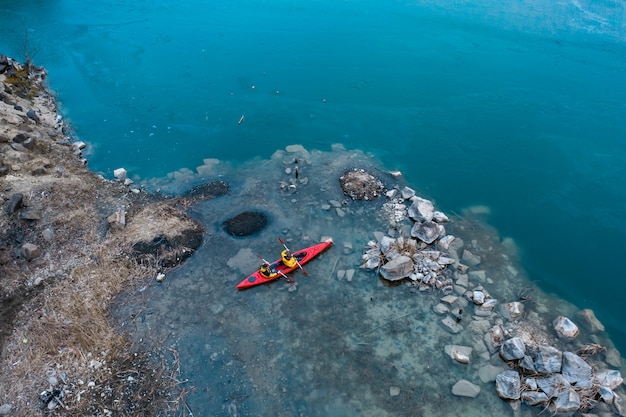 Deux Hommes Athlétiques Flotte Sur Un Bateau Rouge Dans La Rivière Photo gratuit