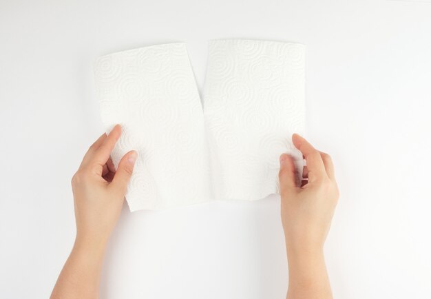 Deux mains féminines tenant une serviette en papier blanc propre pour le visage et le corps Photo Premium