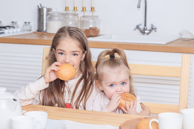 Deux Soeurs A Table Mangeant Du Pain Casse Croute Les Filles Mangent Cuisine Lumineuse Photo Premium