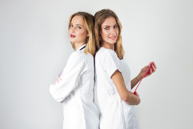 Deux très jeunes femmes médecins, des infirmières qui se tiennent de retour à l'hôpital. Photo gratuit