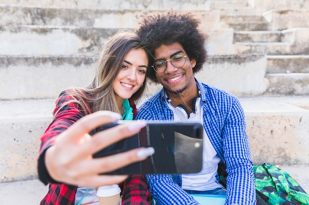 Divers jeune couple prenant selfie sur smartphone Photo gratuit