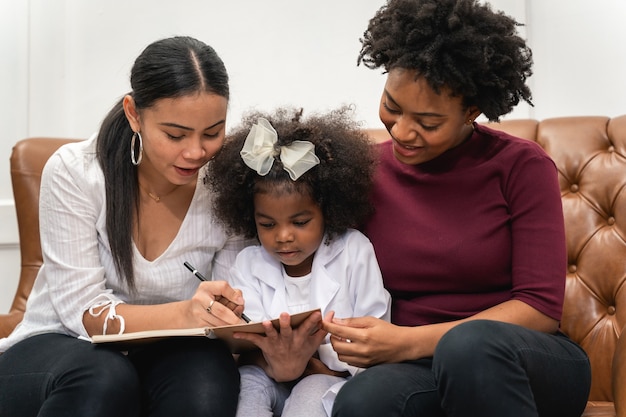 Diversite Lgbt Couple De Lesbiennes Couple De Lesbiennes Avec Sa Fille Africaine En Riant Et Dessinant Une Photo Photo Premium