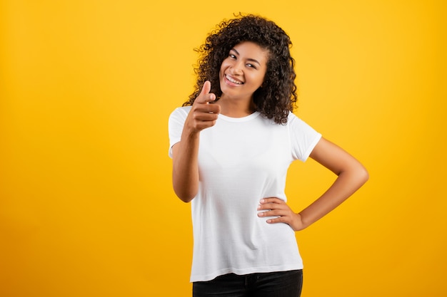 Doigt Pointé De Belle Femme Africaine Noire Isolée Sur Jaune Photo Premium