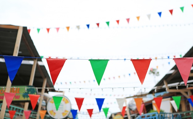 Drapeaux triangulaires multicolores à suspendre entre la vieille maison vintage. Photo Premium