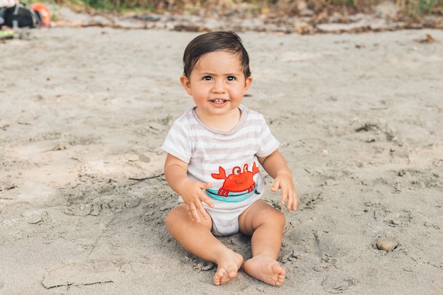 Drole Bebe Assis Sur Une Plage De Sable Fin Photo Gratuite