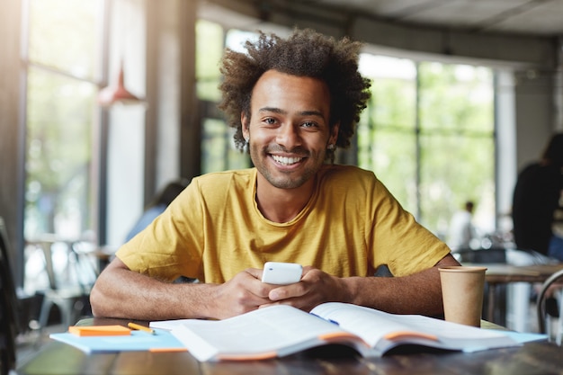 Drole Homme A La Peau Sombre Avec Une Coiffure Africaine Travaillant Sur Du Papier De Cours