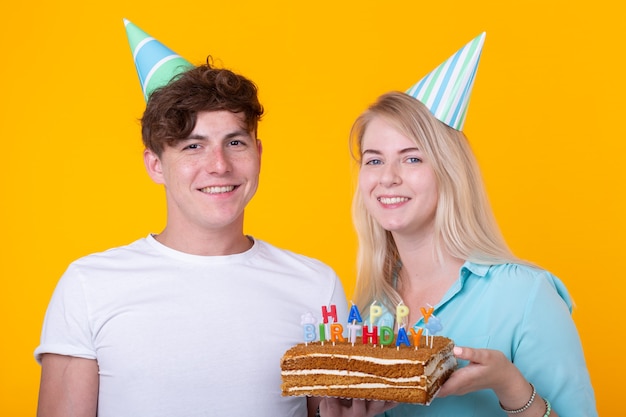 Drole De Jeune Couple Dans Des Casquettes De Papier Et Avec Un Gateau Faire Une Grimace