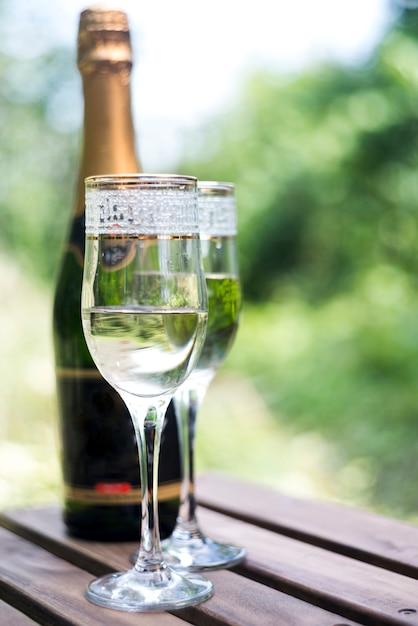 Elegants Verres De Champagne Avec Une Bouteille De Champagne Sur Une Table En Bois Photo Gratuite