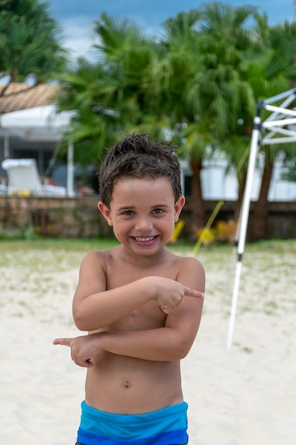 Enfant De 5 Ans Posant Pour La Photo Sur Le Sable De La Plage Photo Premium