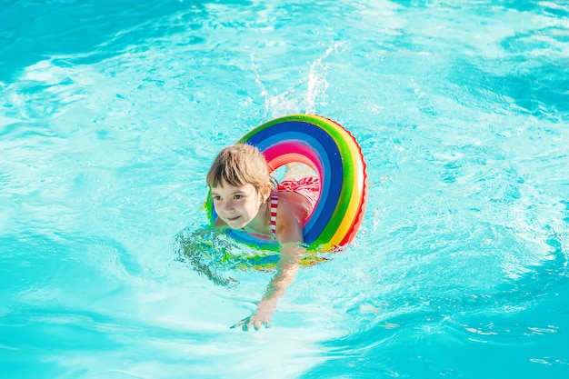 Un Enfant Nage Dans Une Piscine Avec Un Gilet De Sauvetage Mise Au Point Selective Photo Premium