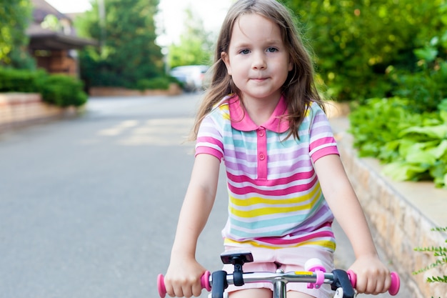 Les Enfants Font Du Velo Pres De La Maison Une Petite Fille A Bicyclette Par Une