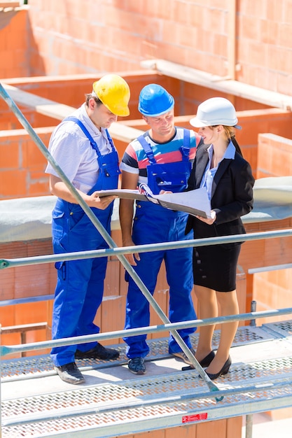 Équipe discutant des plans de construction ou de chantier Photo Premium