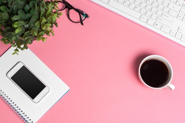 Espace de travail créatif rose de la femme avec clavier et fournitures, vue de dessus Photo Premium