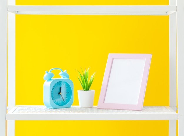 Étagère blanche avec des objets de papeterie contre jaune vif Photo Premium