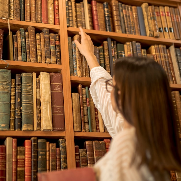 Excellente étudiante Choisir Livre Vintage Dans La Bibliothèque Photo Gratuite 