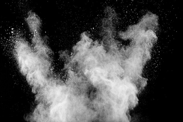 Explosion de poudre blanche isolée sur fond noir. éclaboussures de particules de poussière blanche. Photo Premium