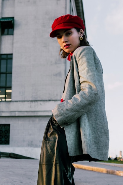 Faible angle de vue de la jeune femme à la mode avec ses mains dans la poche Photo gratuit