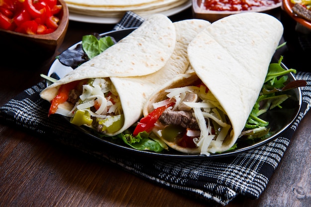 Fajitas au poulet et au bœuf avec légumes et tortillas Photo Premium