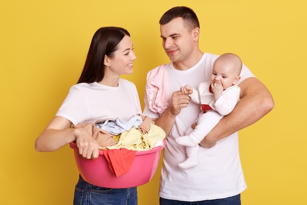 Famille Avec Lessive Isolee Sur Mur Jaune Papa Tenant La Petite Fille Nouveau Nee Dans Les