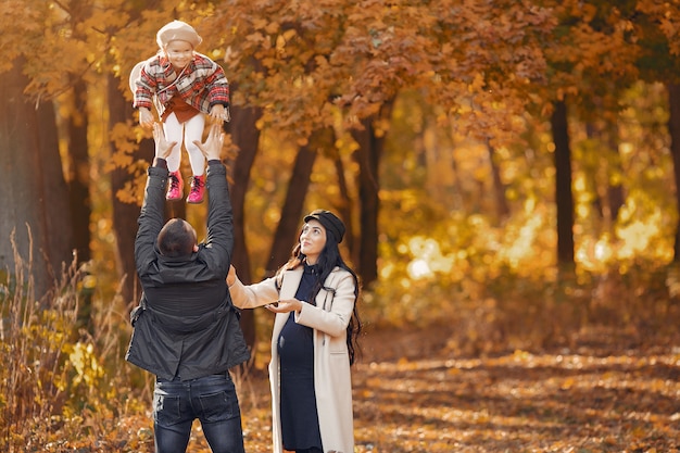Famille avec petite fille dans un parc en automne Photo gratuit