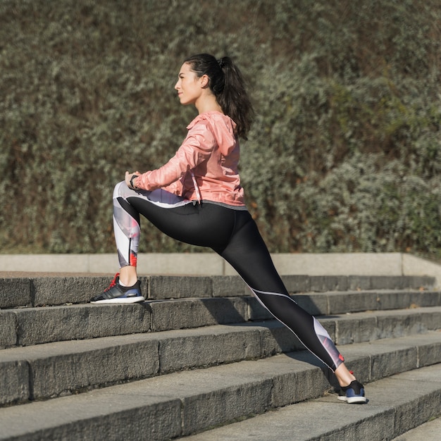 Femme active qui s'étend en plein air Photo gratuit