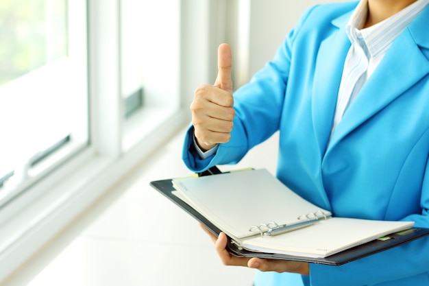 Femme d'affaires en costume lève sa main faire le signe superbe Photo Premium