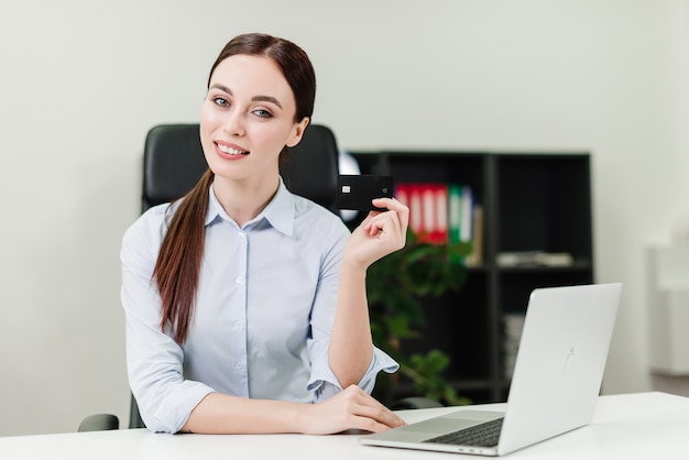 Femme d'affaires effectuant des paiements et des transferts d'argent via une banque mobile en utilisant une carte de crédit et un ordinateur portable Photo Premium