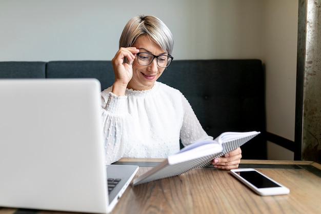Femme d'affaires vue de face au bureau Photo gratuit