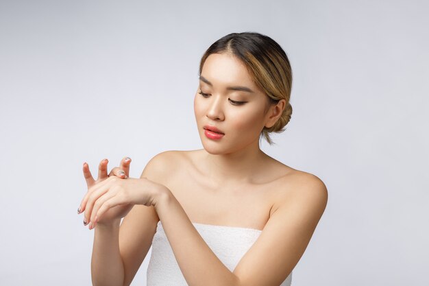 Femme asiatique, application, crème cosmétique, peau, fond blanc isolé Photo Premium