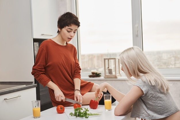 Femme Assise Sur La Table  De Tomates Pendant Que Son Amie 