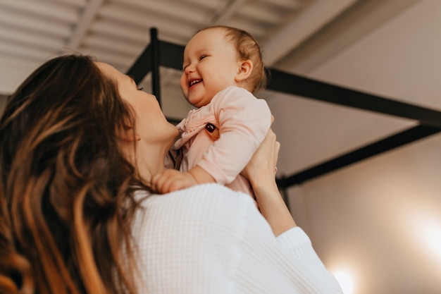 Femme Aux Cheveux Longs Chatouille Et Vomit Bebe En Riant Dans Un Pull Maison De Couleur Claire Photo Gratuite