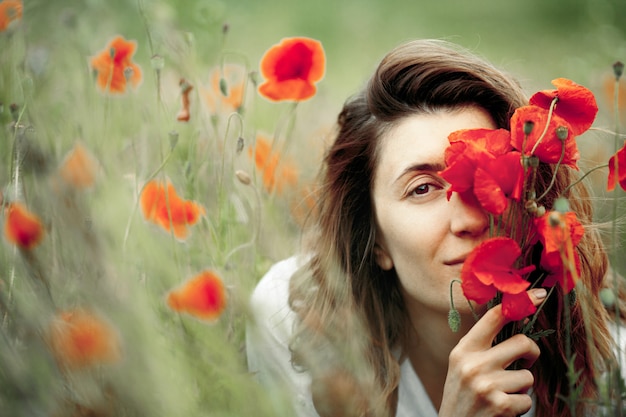 Femme Couvre Un Visage Avec Un Bouquet De Fleurs De Coquelicots Photo Gratuite