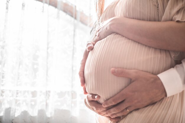 Femme Enceinte Et Son Mari Tenant La Main En Forme De Coeur Sur La Bosse De