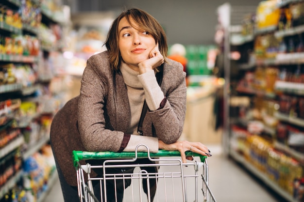 Femme faisant ses courses à l'épicerie Photo gratuit