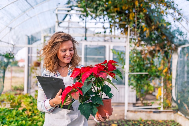 Femme De Fleuriste Souriante Tenant Un Pot De Fleurs Avec