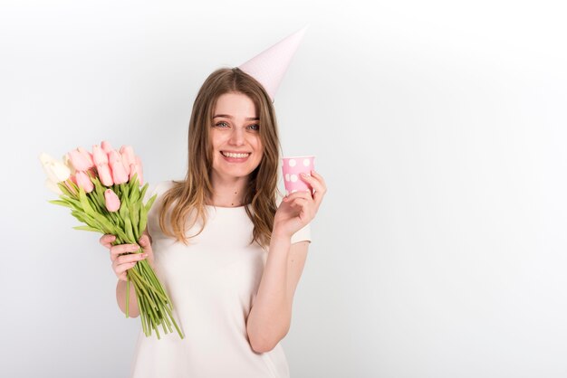 Photo Gratuite Femme Heureuse En Bonnet D Anniversaire Avec Des Fleurs